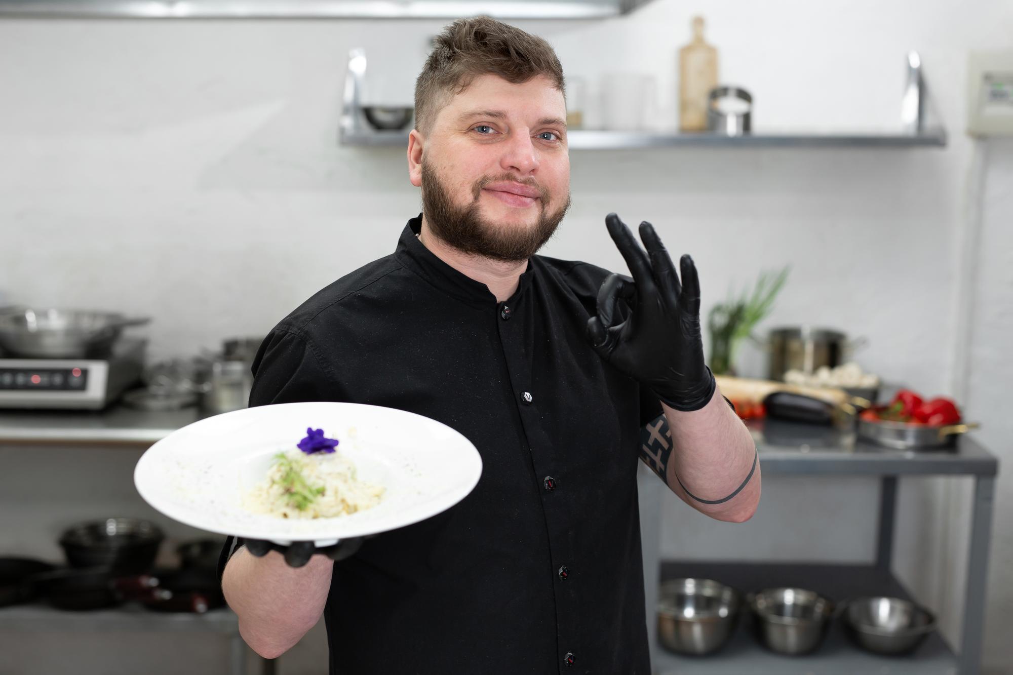 chef offering plated course to camera